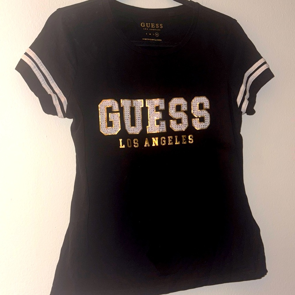 T-shirt features a script logo design in lettering embellished with rhinestones.